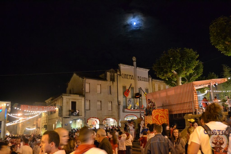 Photo de nuit foule sur la place de Vic-Fezensac pendant Pentecotavic 2011, lune au-dessus de la façade du cinéma Bravia